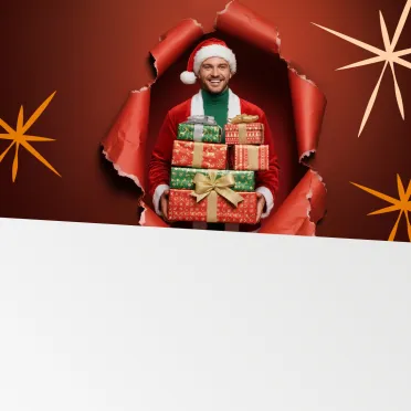 mężczyzna w czapce mikołaja trzymający prezenty